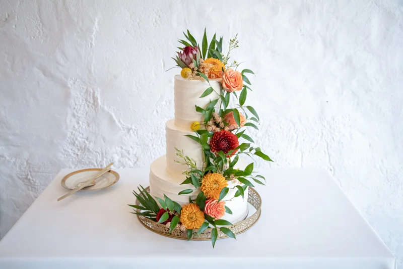 Hochzeitstorte-weiß-mit-Blumen-Wasserfall-coucoucake
